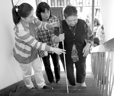 老师指导盲人使用盲杖进行上下楼行走训练 老师指导盲人使用盲杖进行上下楼行走训练